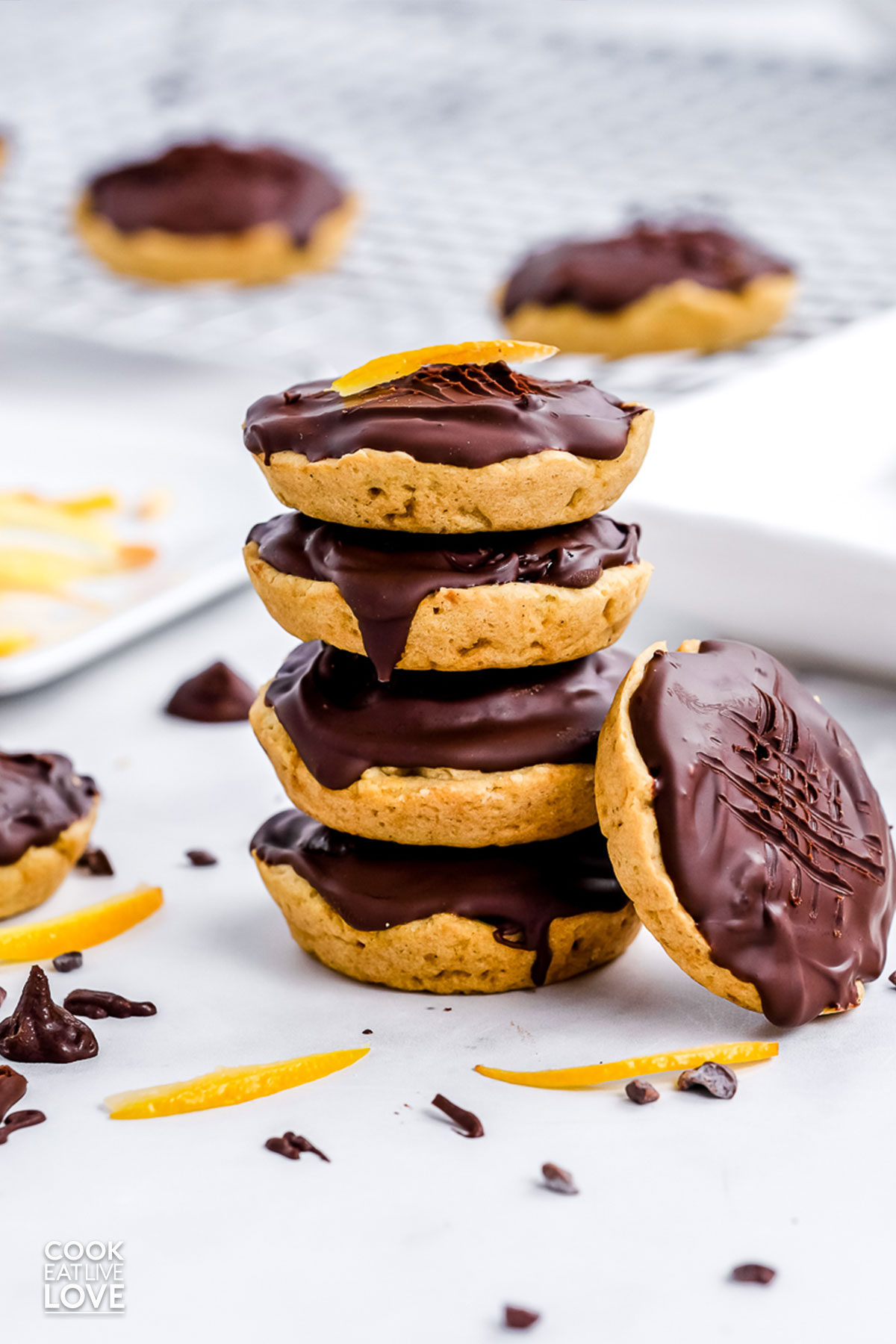 Four jaffa cakes stacked on top of each other and one at an angle propped on the stack.