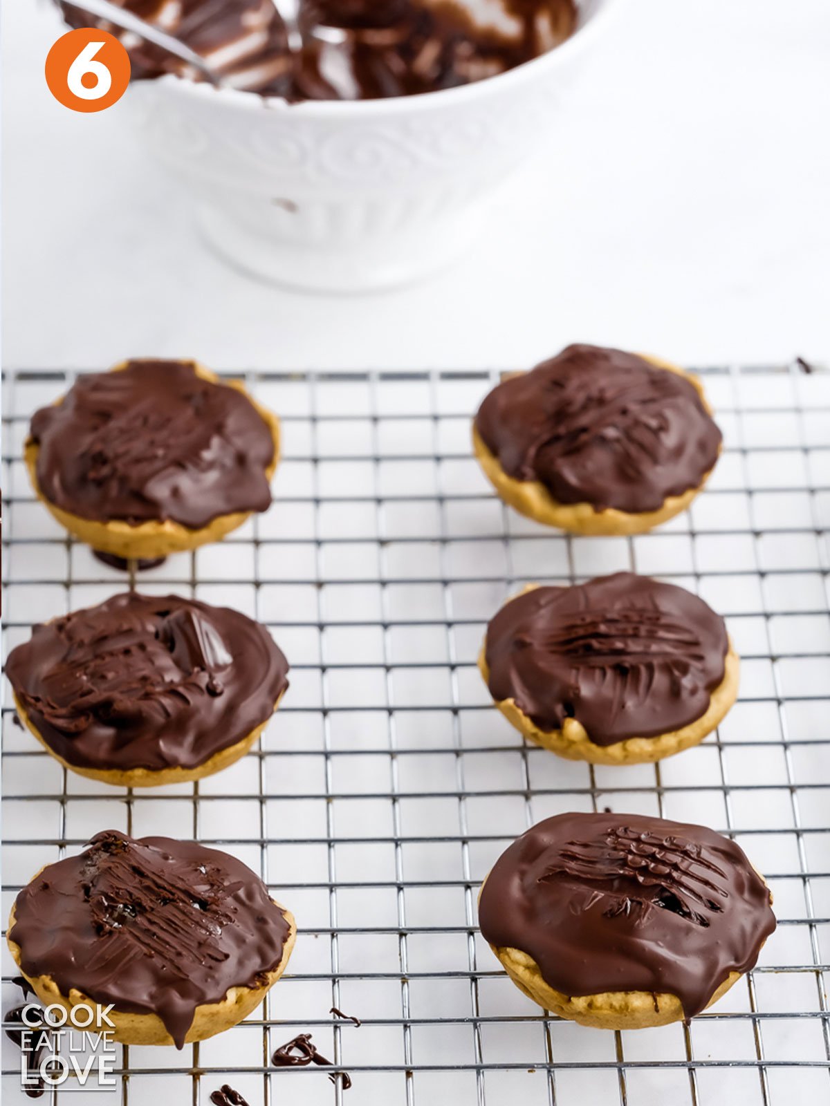 Jaffa cakes topped with chocolate all ready to eat on a wire rack.