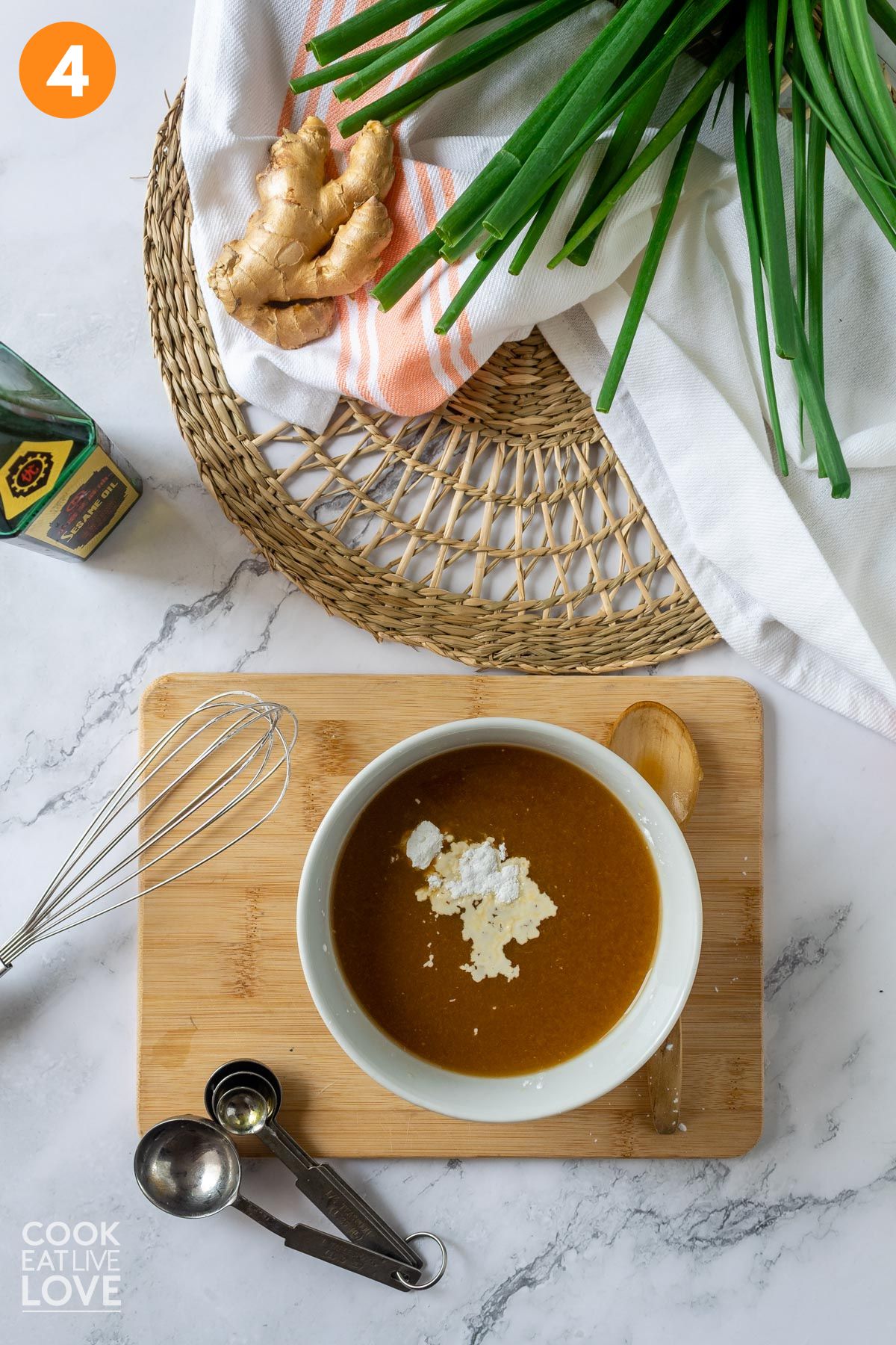 Cornstarch added to the bowl of orange sauce.
