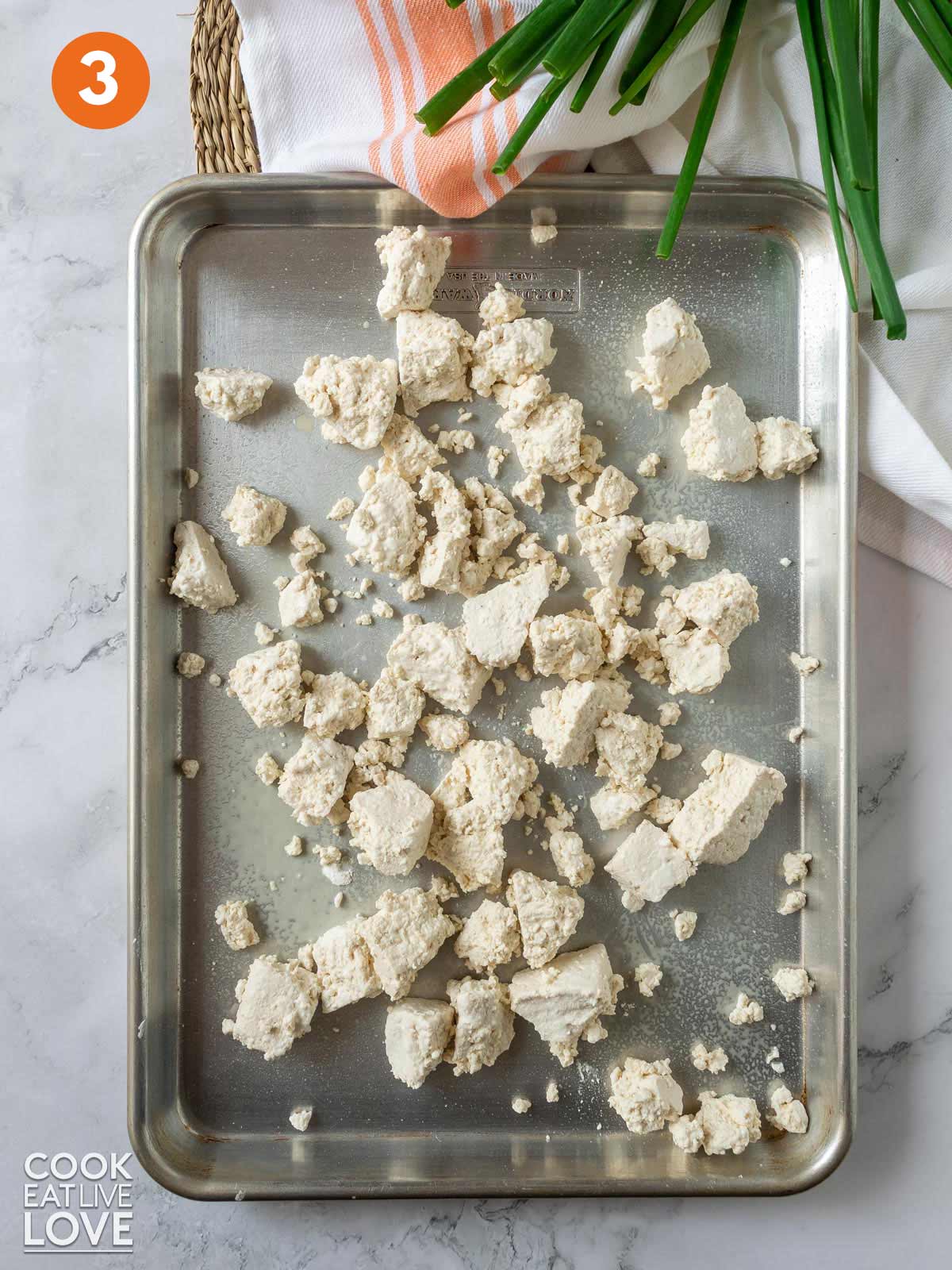 Tofu spread out on a pan to cook.