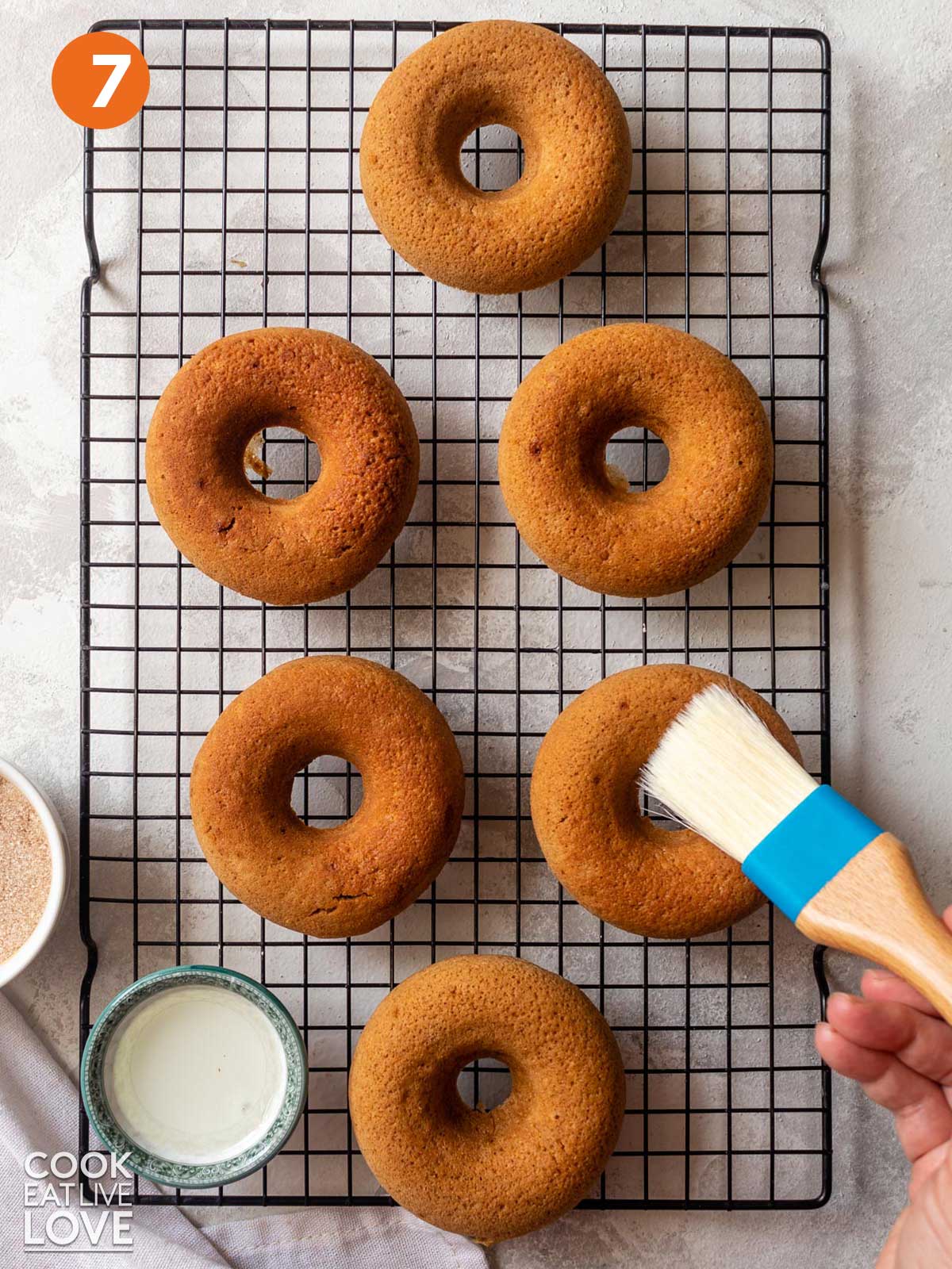 Brushing donuts with coconut oil.