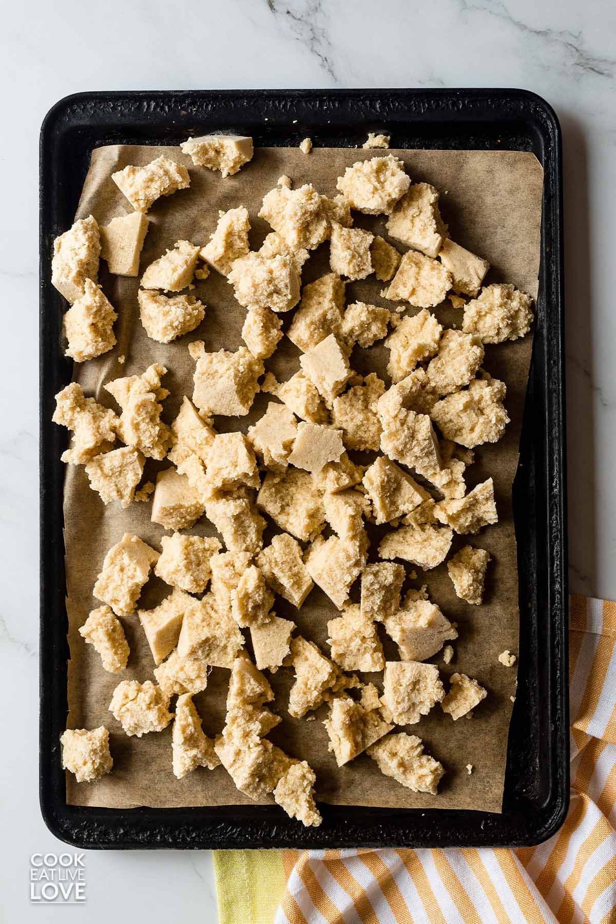 Large chunks of tofu frozen on a baking tray.