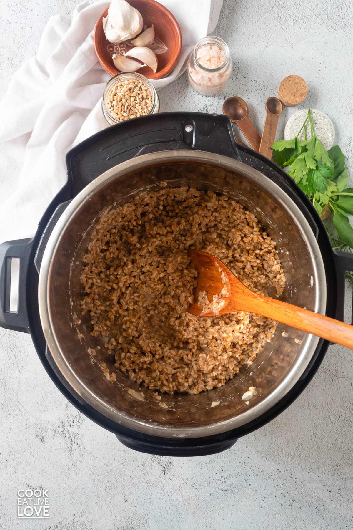 Instant pot farro pilaf cooked with a wooden spoon inside.
