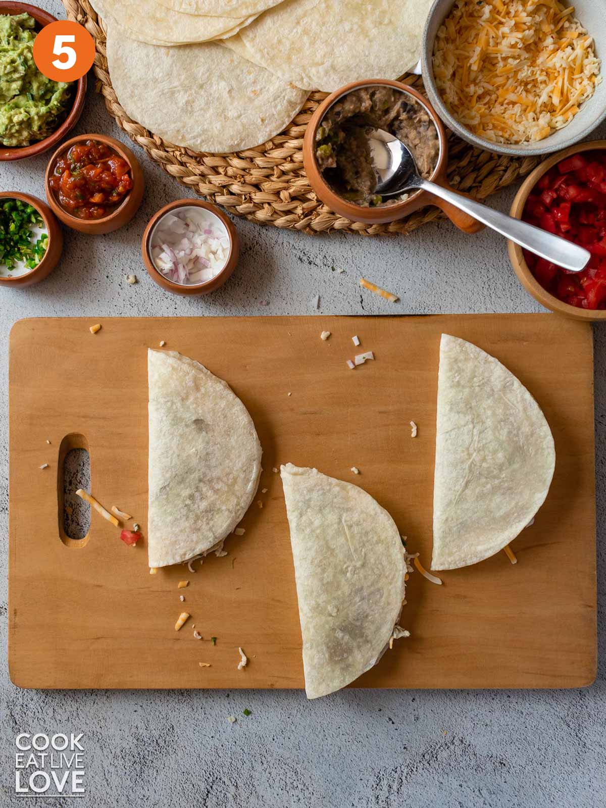 Air fryer quesadillas filled and folded on a cutting board.