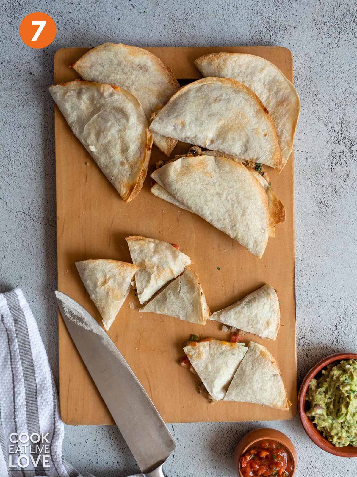 Air fryer quesadillas cooked and cut into triangles on a cutting board.