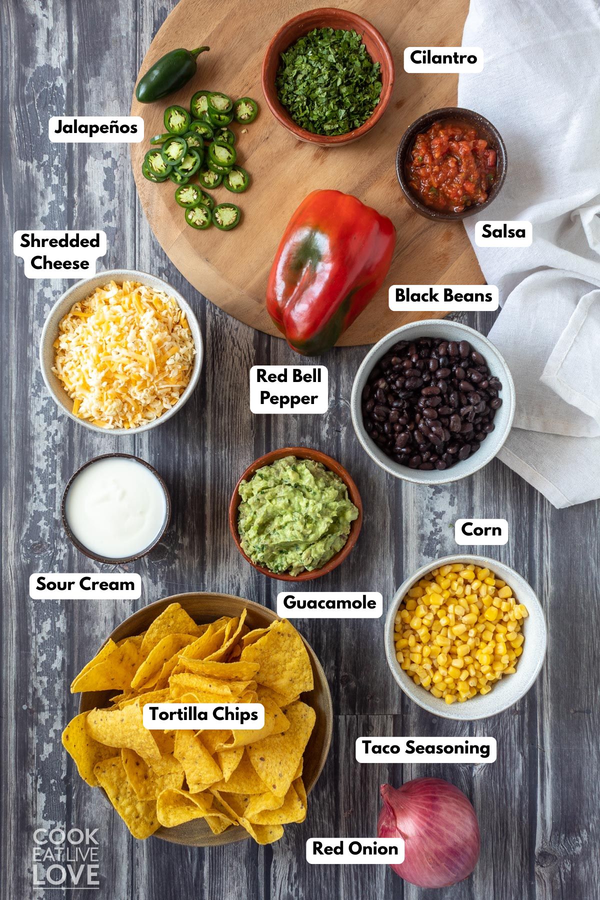 Ingredients to make black bean nachos in bowls on a countertop. 