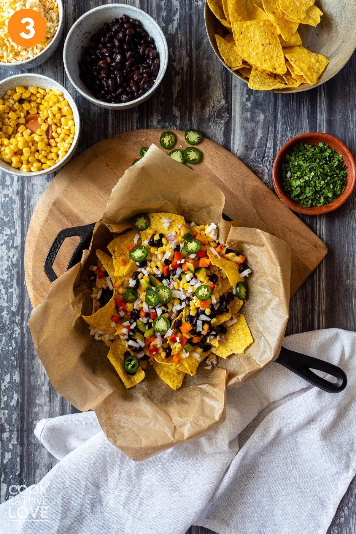 Adding a second layer of chips and veggies on top 
