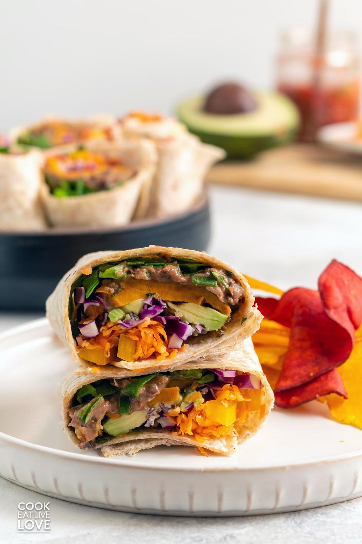 Southwest veggie wrap cut in half and stacked on top of each other on a plate.