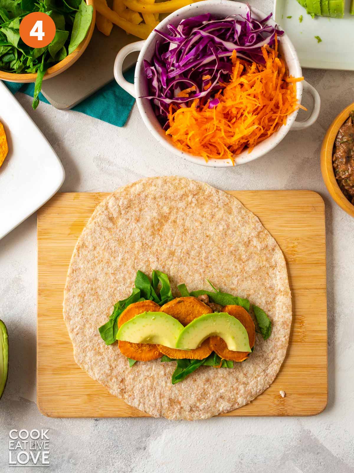Southwest veggie wrap with sweet potatoes and avocado added on top.
