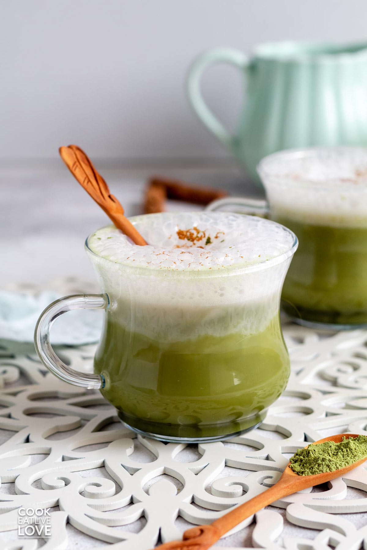 A matcha chai latte in a glass mug on the table.