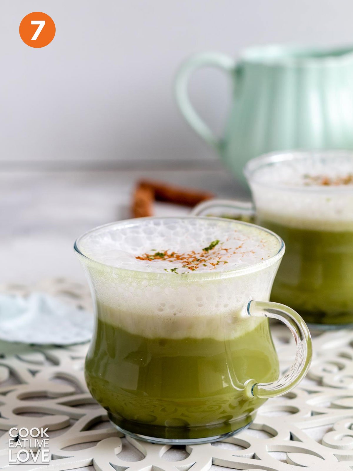 A finished matcha chai latte with milk foam on the table.