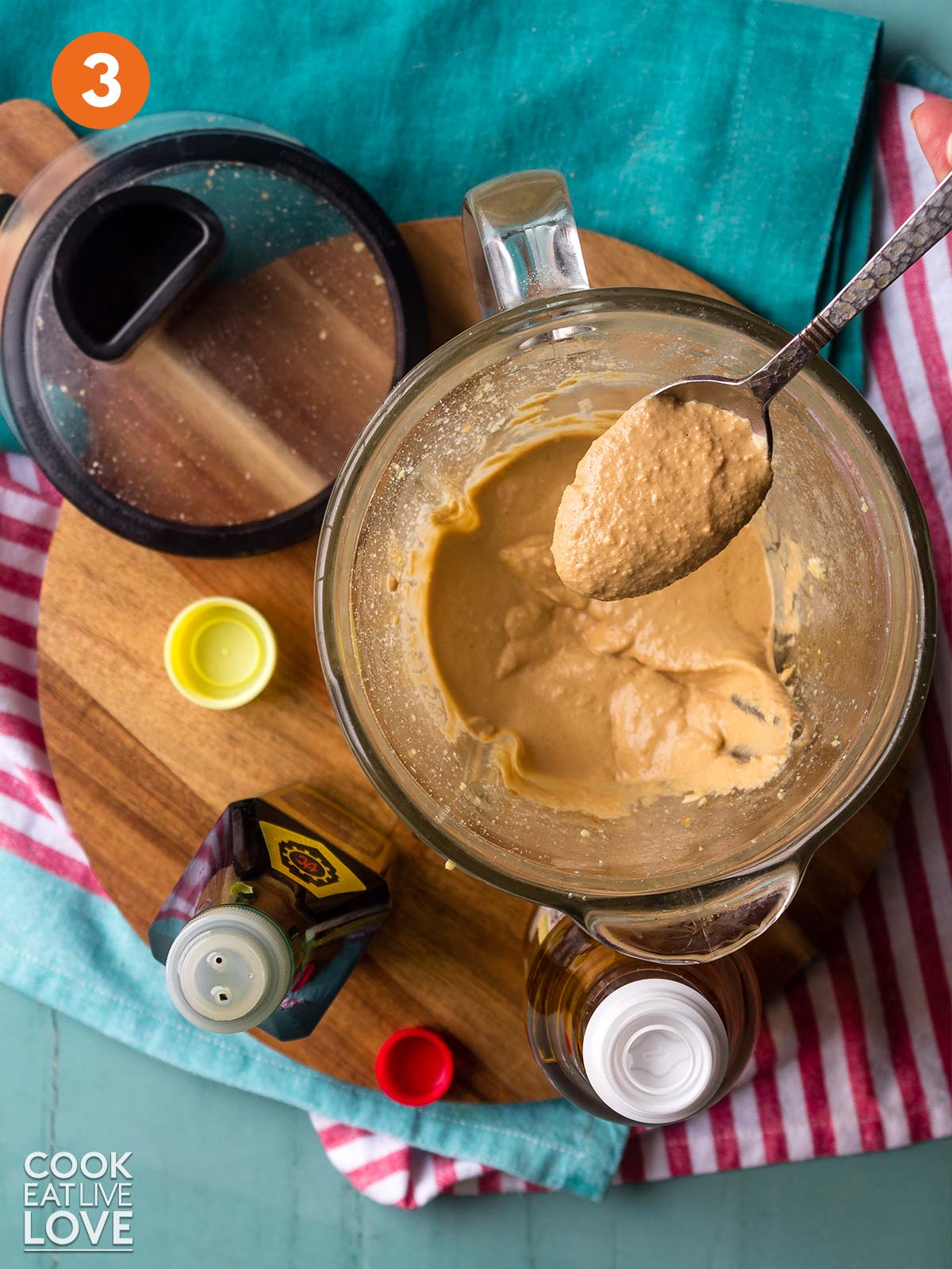 A spoonful of creamy peanut sauce up over the blender.