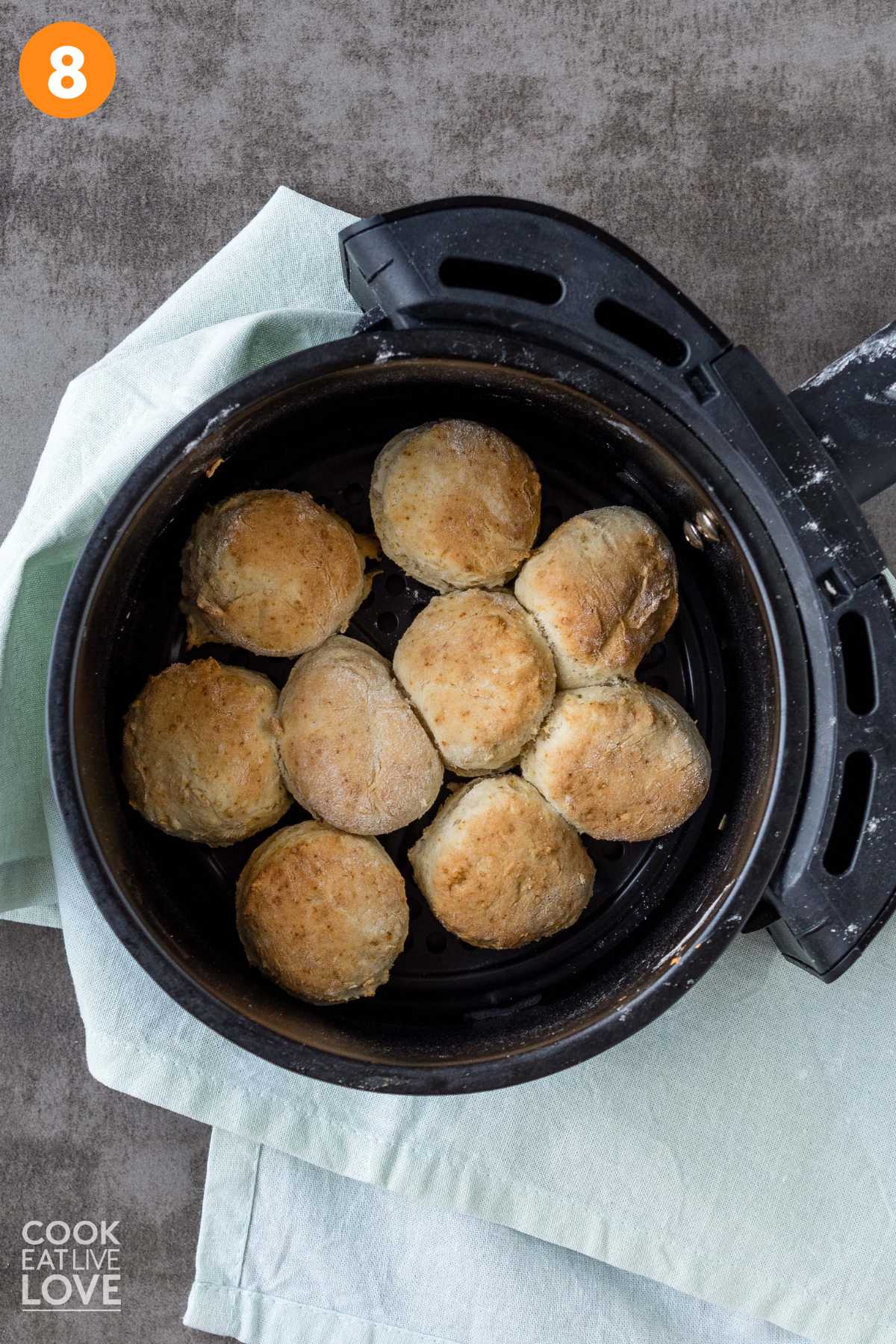 Air fryer biscuits golden brown in the air fryer basket.