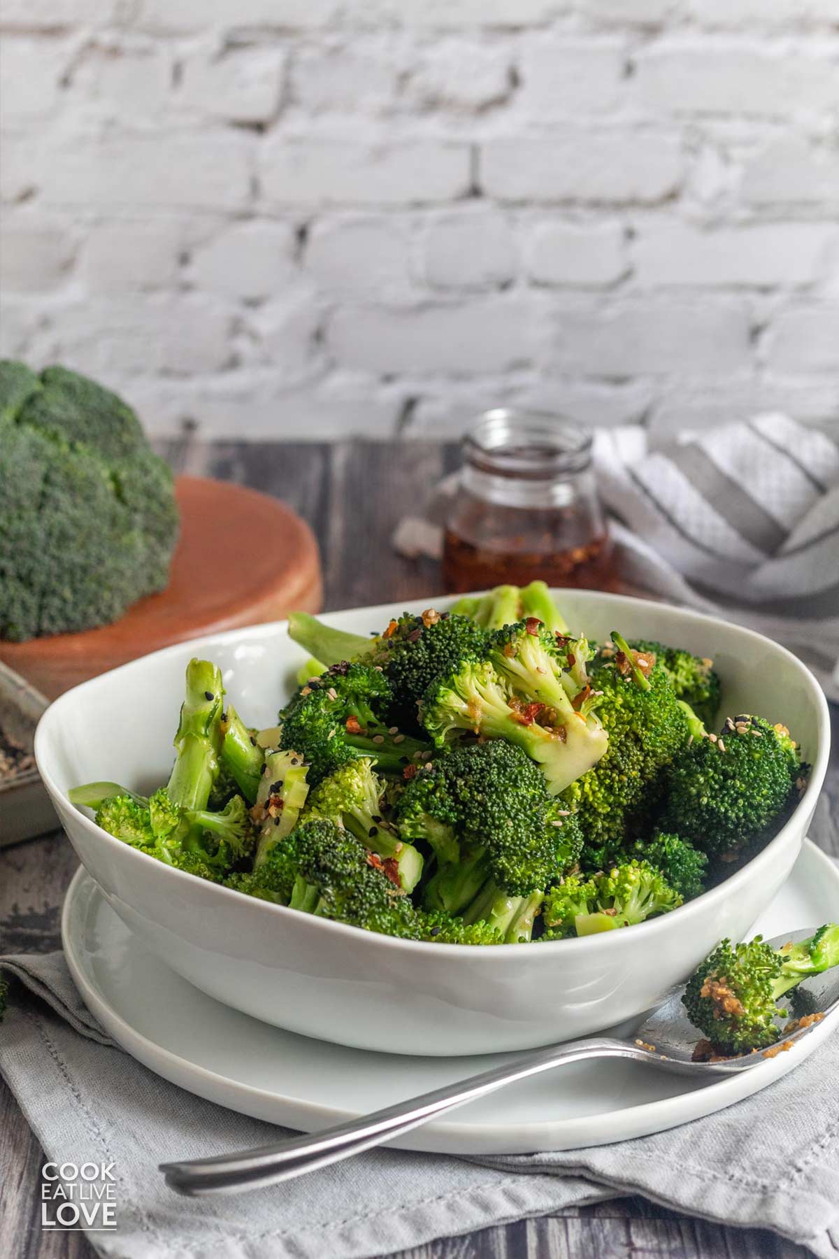 A bowl of asian broccoli on the table in a white bowl.