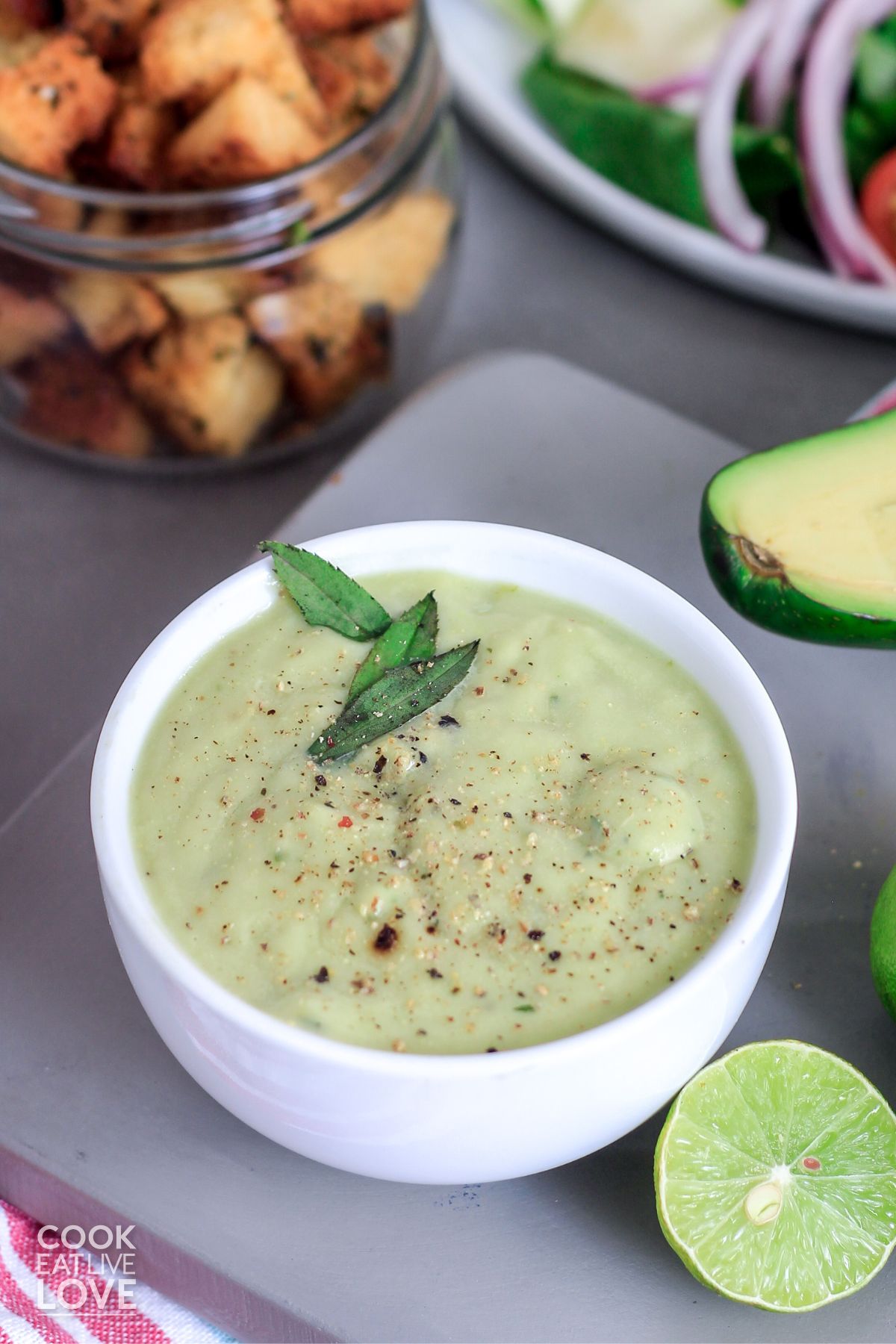 Avocado lime dressing in a white bowl on the table
