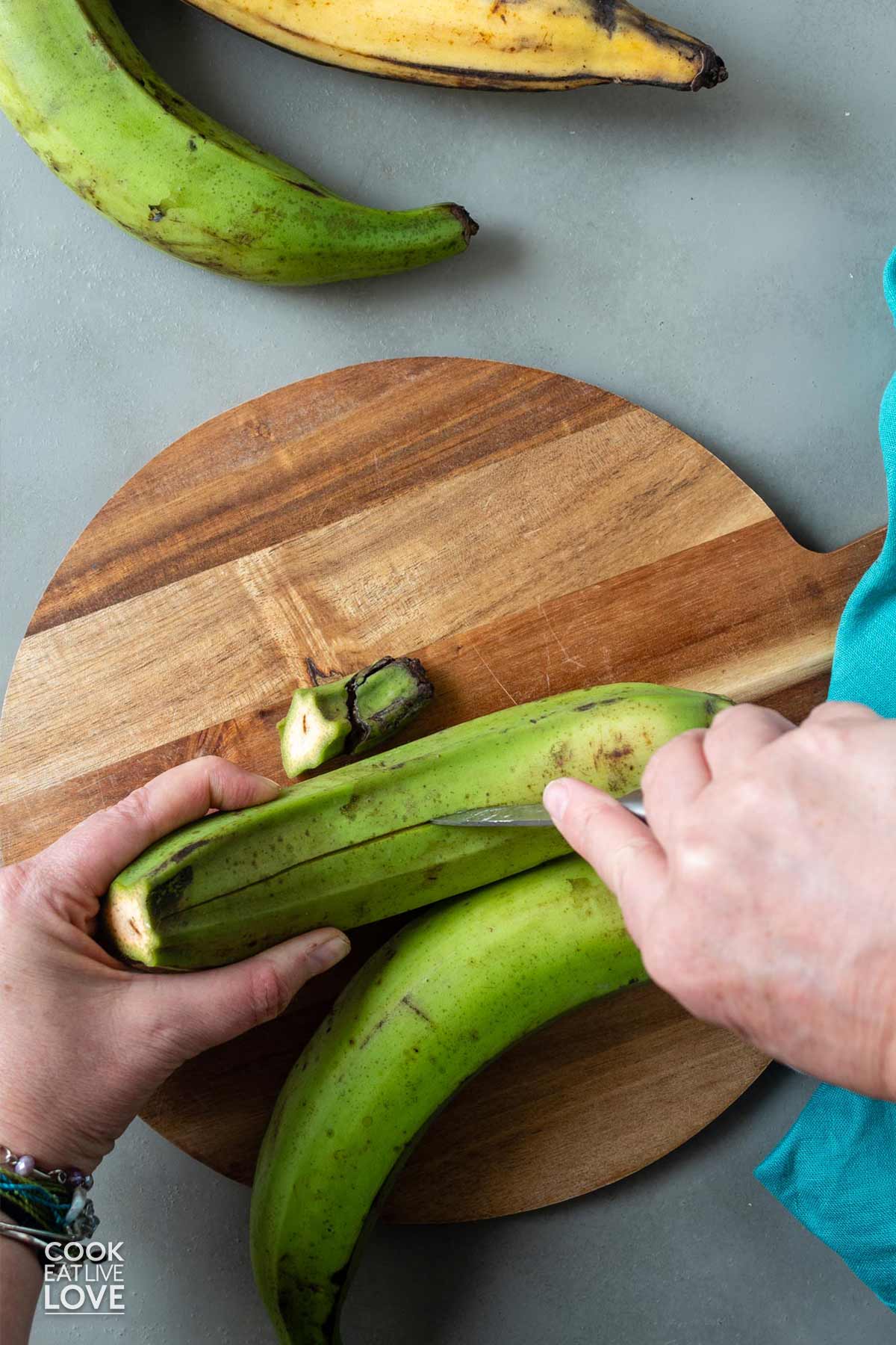 Cutting a slit in the peel of a plantain.