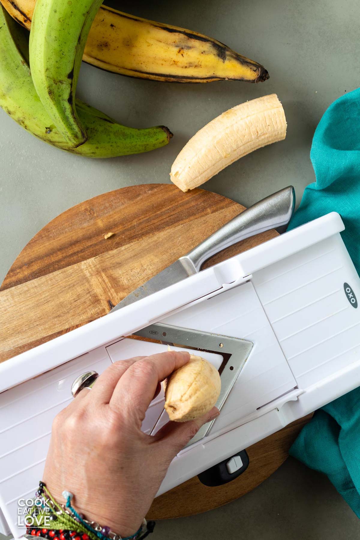 Using a mandolin slicer to cut the plantain.