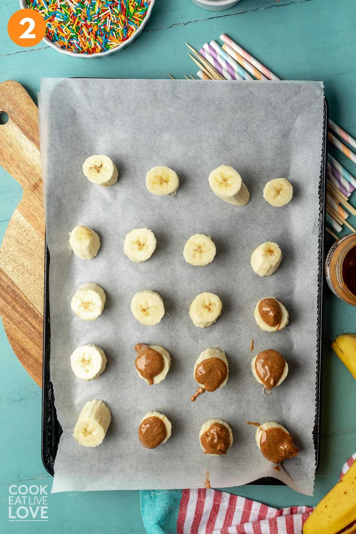 Bananas are shown cut into pieces and topped with nut butter.