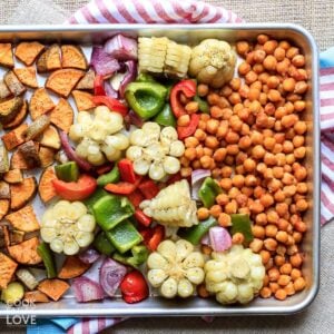 A baking pan with bbq chickpeas and veggies after cooking on top of a striped tea towel.