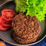 Stack of black bean quinoa burgers on a plate ready to eat.