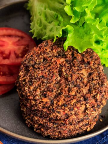Stack of black bean quinoa burgers on a plate ready to eat.