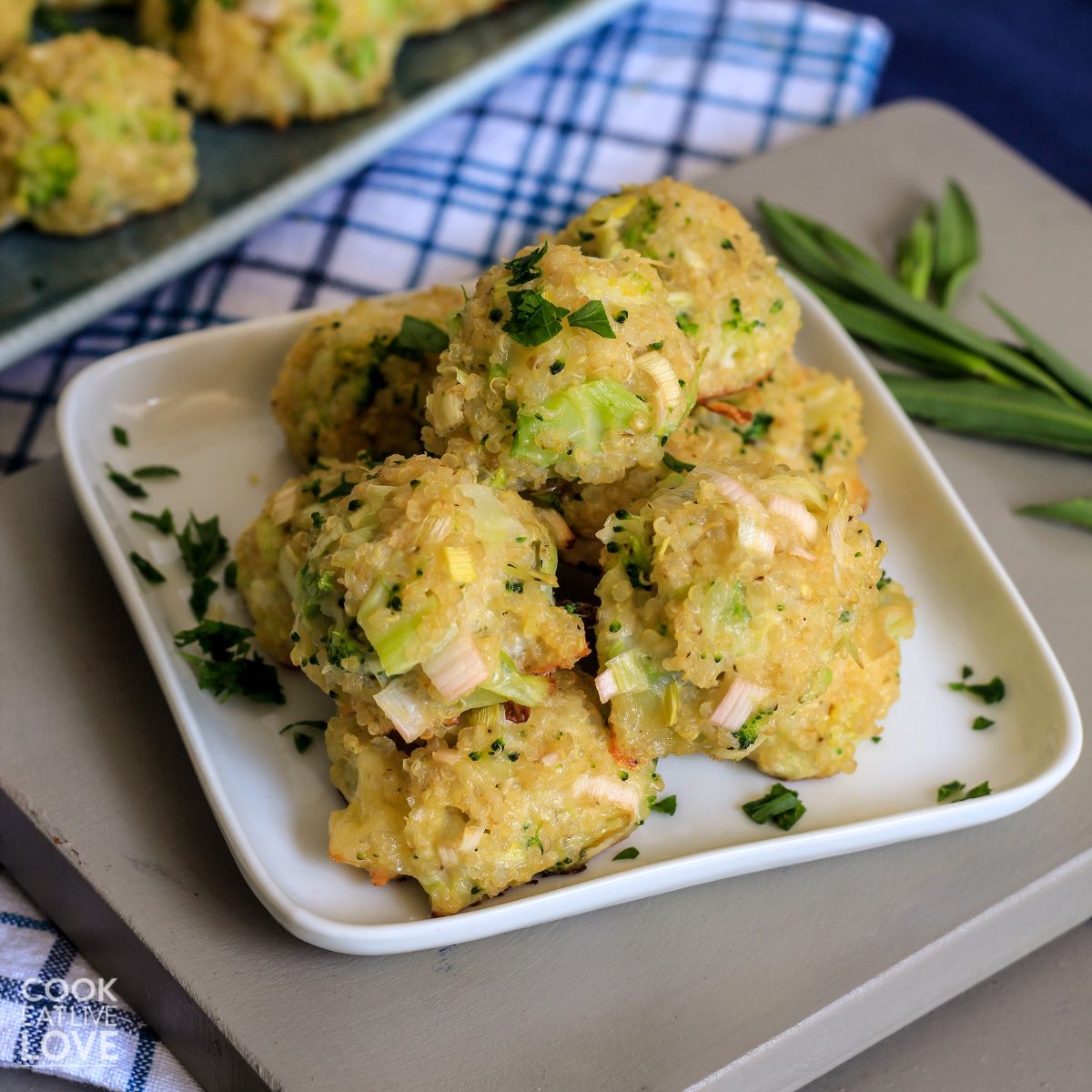 Cheese and broccoli bites are stacked up on a white plate on the table.