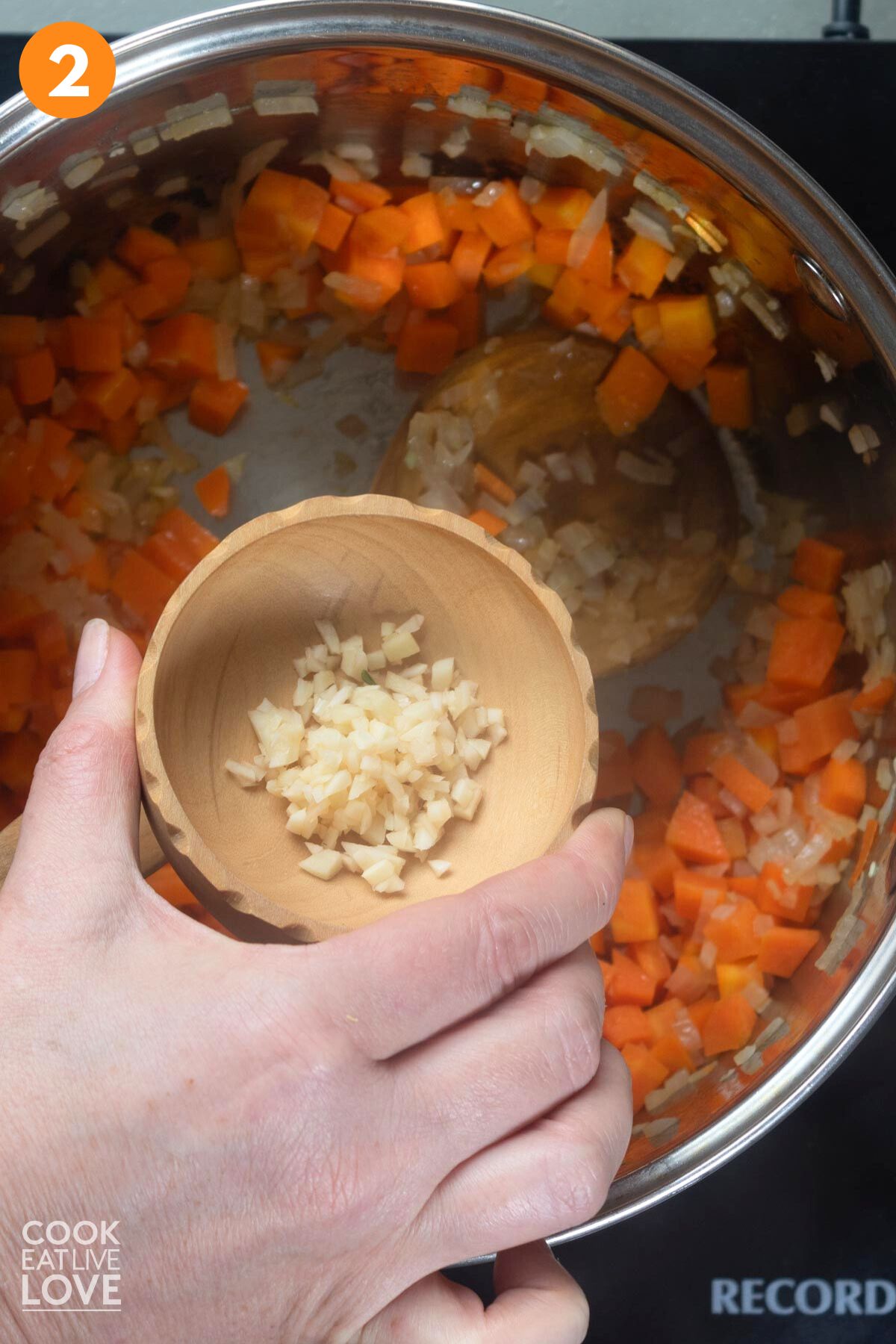 Adding garlic to cooked carrots and onions