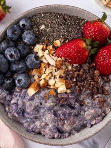 A bowl of chia seed overnight oats topped with a variety of different toppings.