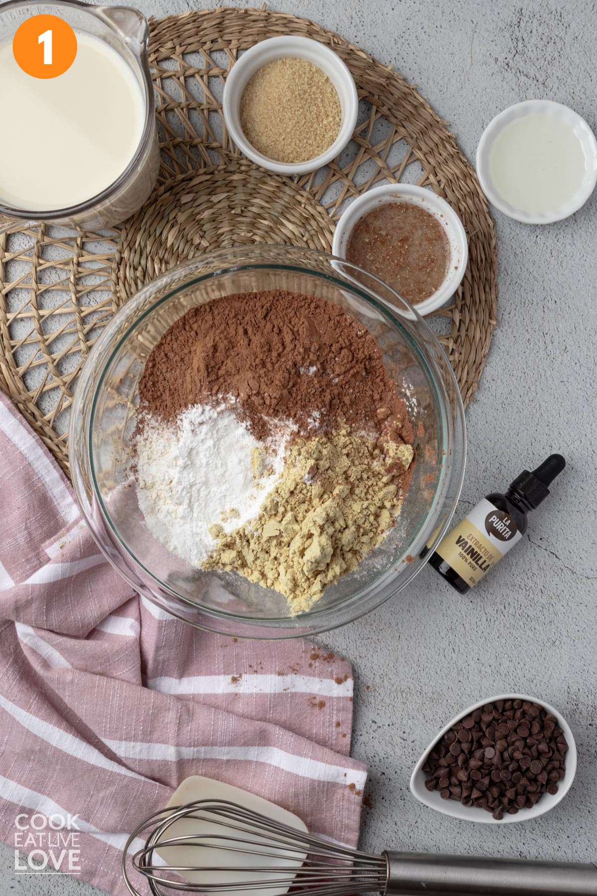 Dry ingredients added to a bowl to make vegan chocolate pancakes.