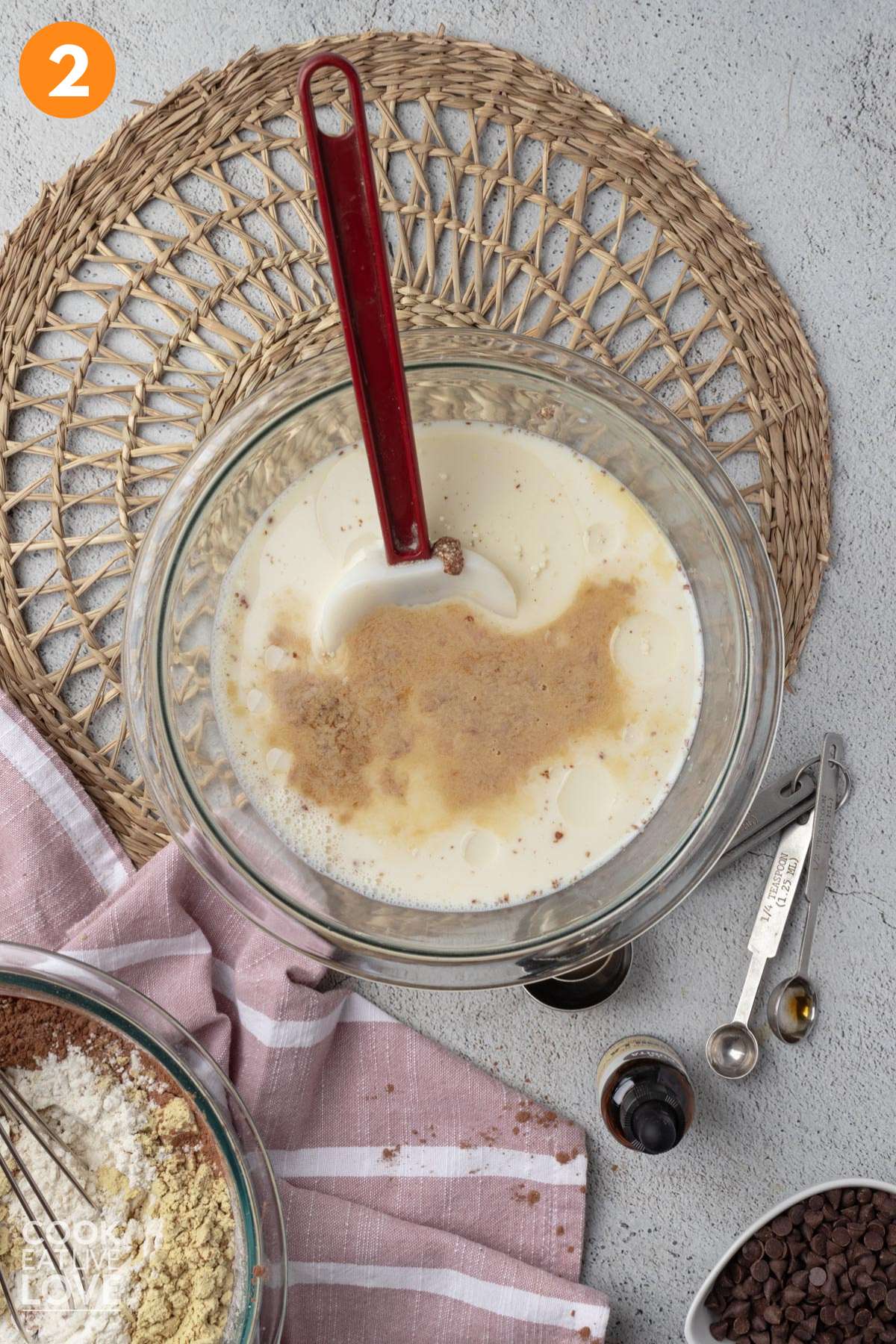 Milk, sugar, and other wet ingredients in a glass bowl.