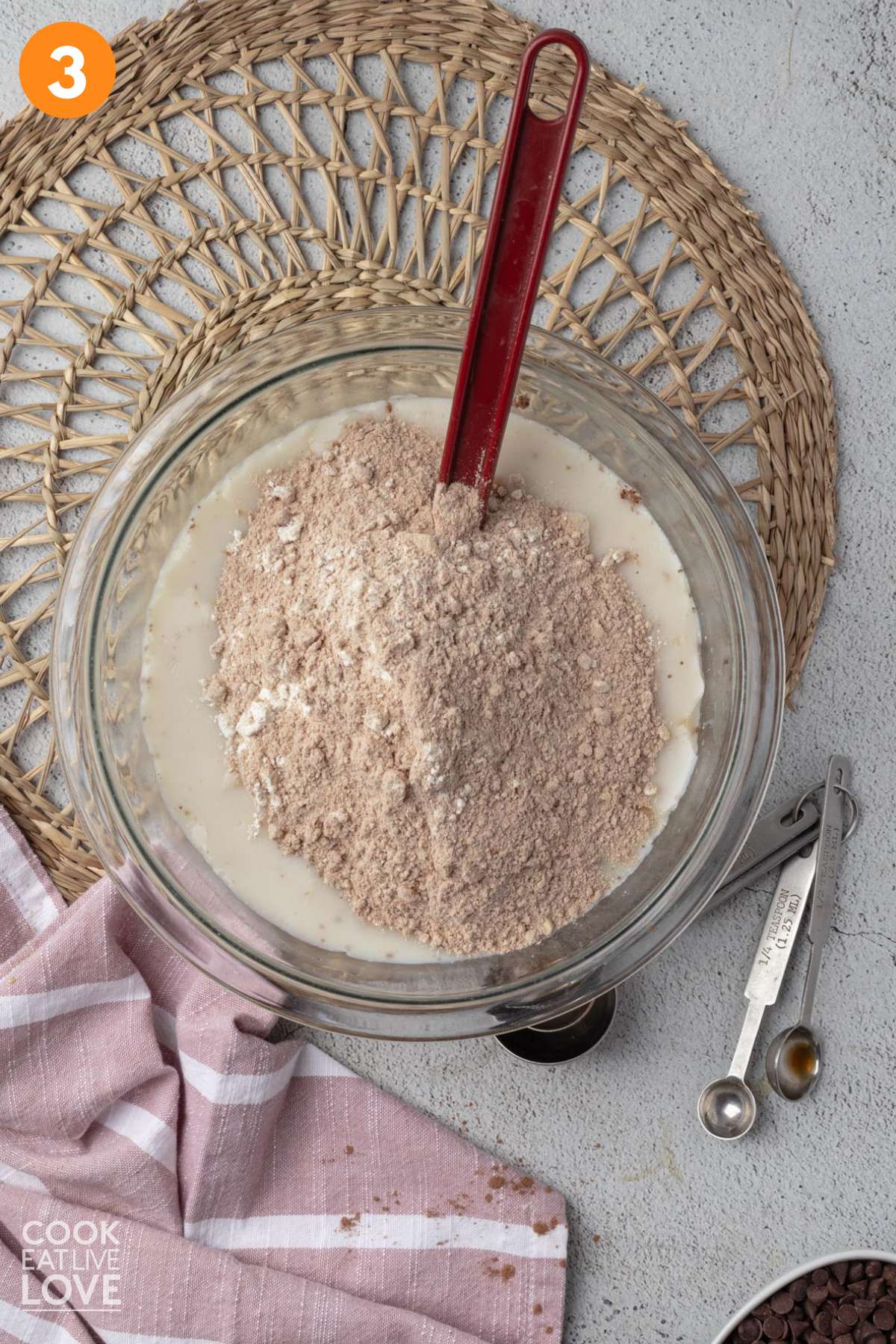 Dry ingredients added to the bowl of wet ingredients to mix up chocolate pancakes.