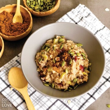 A bowl of healthy quinoa flake porridge sitting on a table on White And Gray Plaid napkin
