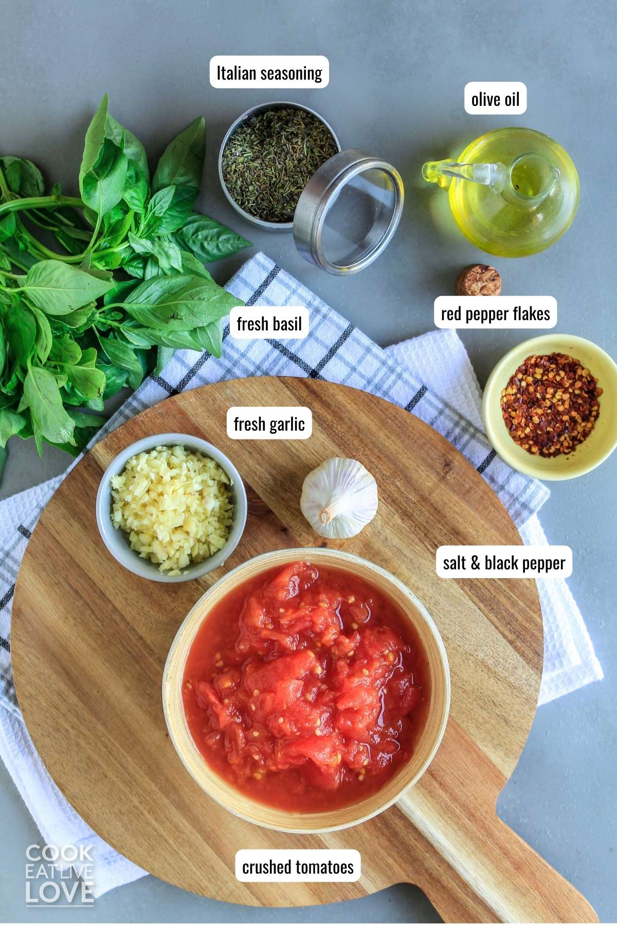 Ingredients to make hearty marinara sauce on table with text labels next to them.