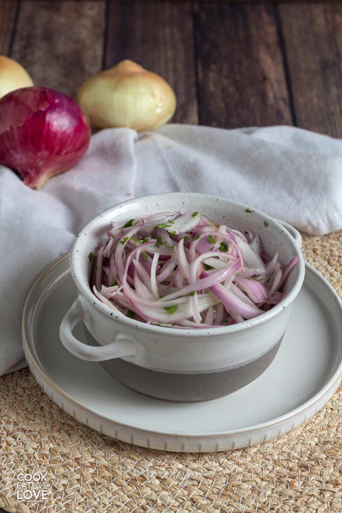 A bowl of red onion salad on a plate on the table.