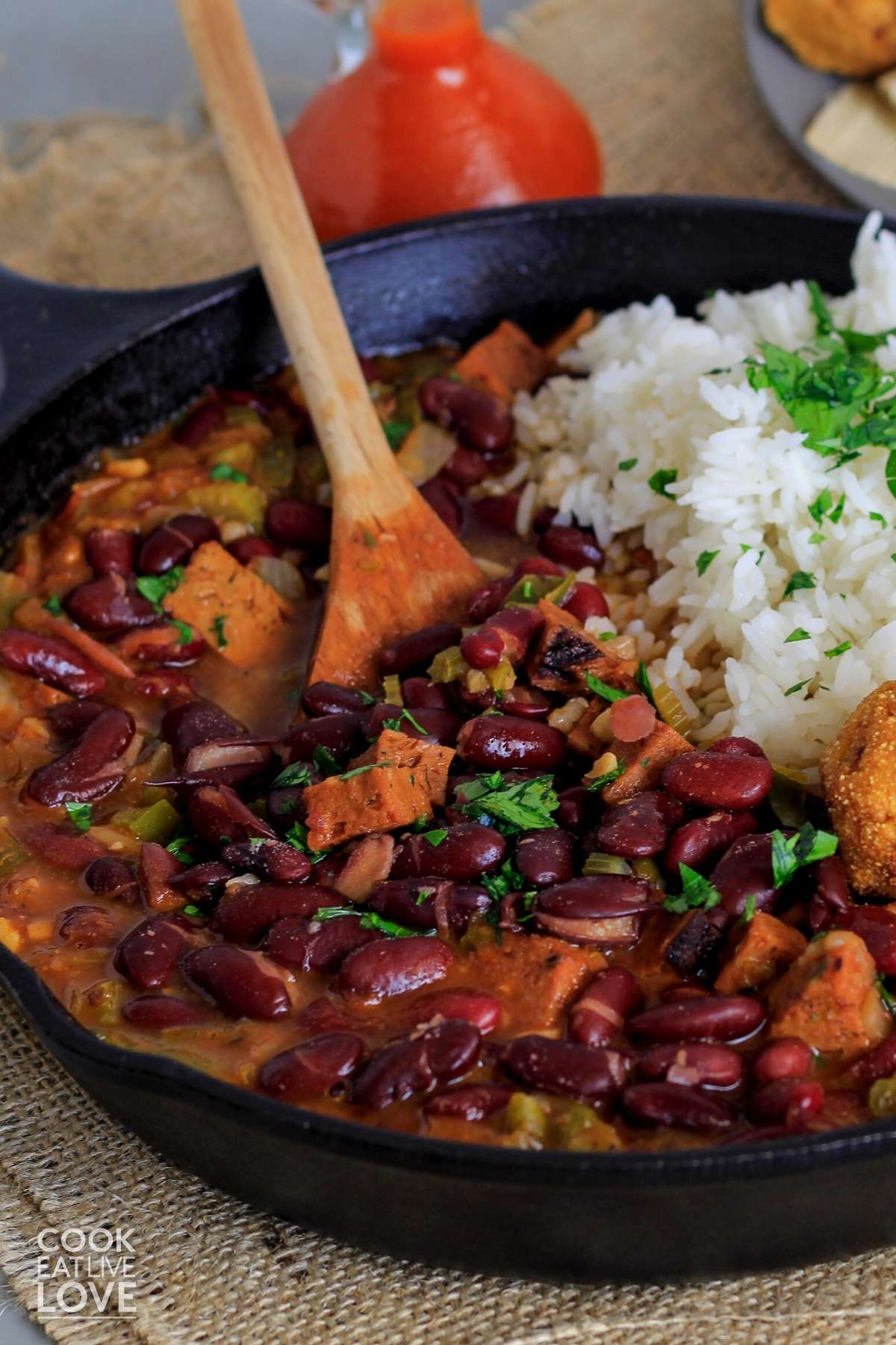 Skillet with red beans and rice on the table with wooden spoon in the dish.