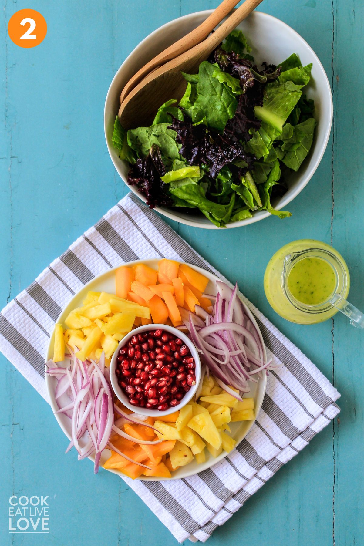 Prepped fruit and bowl of greens on countertop