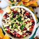 Overhead view of bowl of dip surrounded by pita chips.