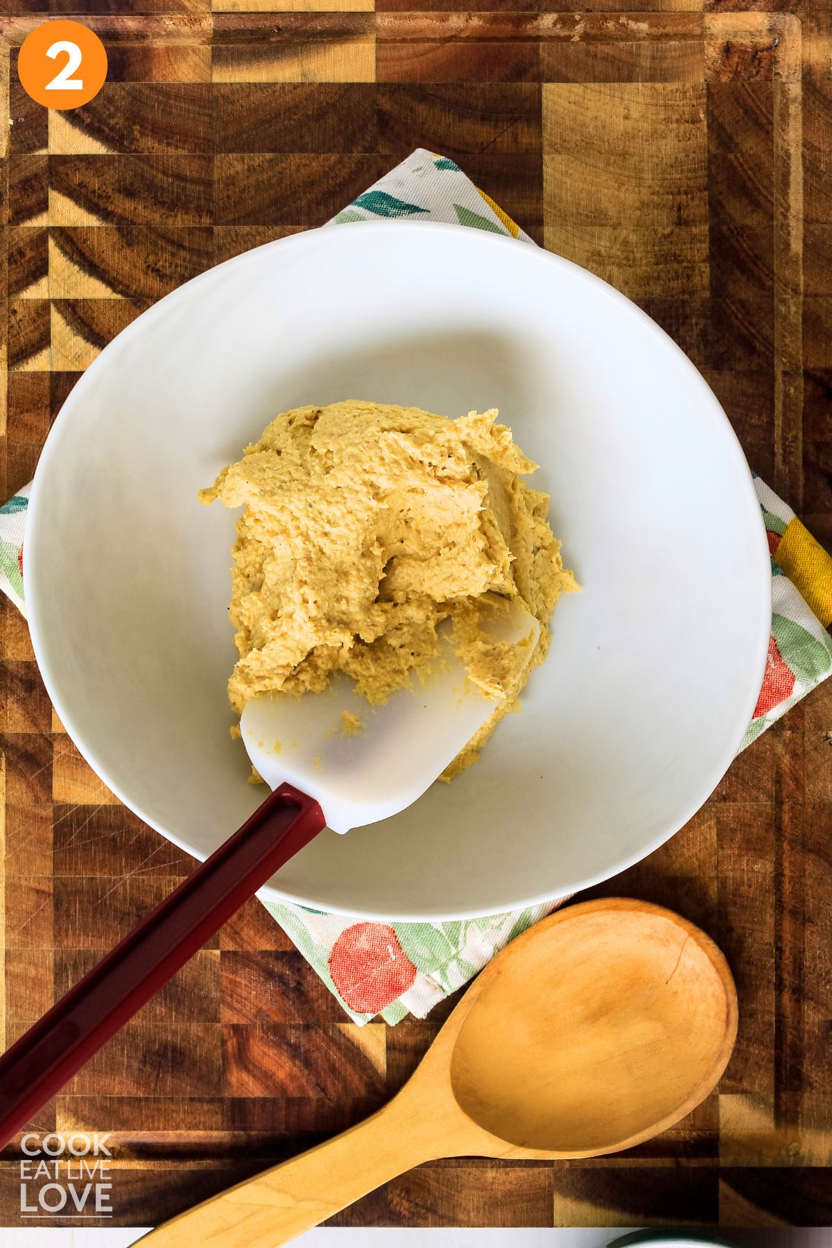 Pita bread on a pan with a pastry brush topping them with olive oil