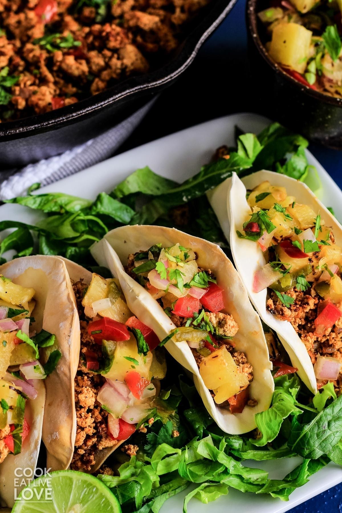 Taco bites on a plate topped with pineapple salsa.