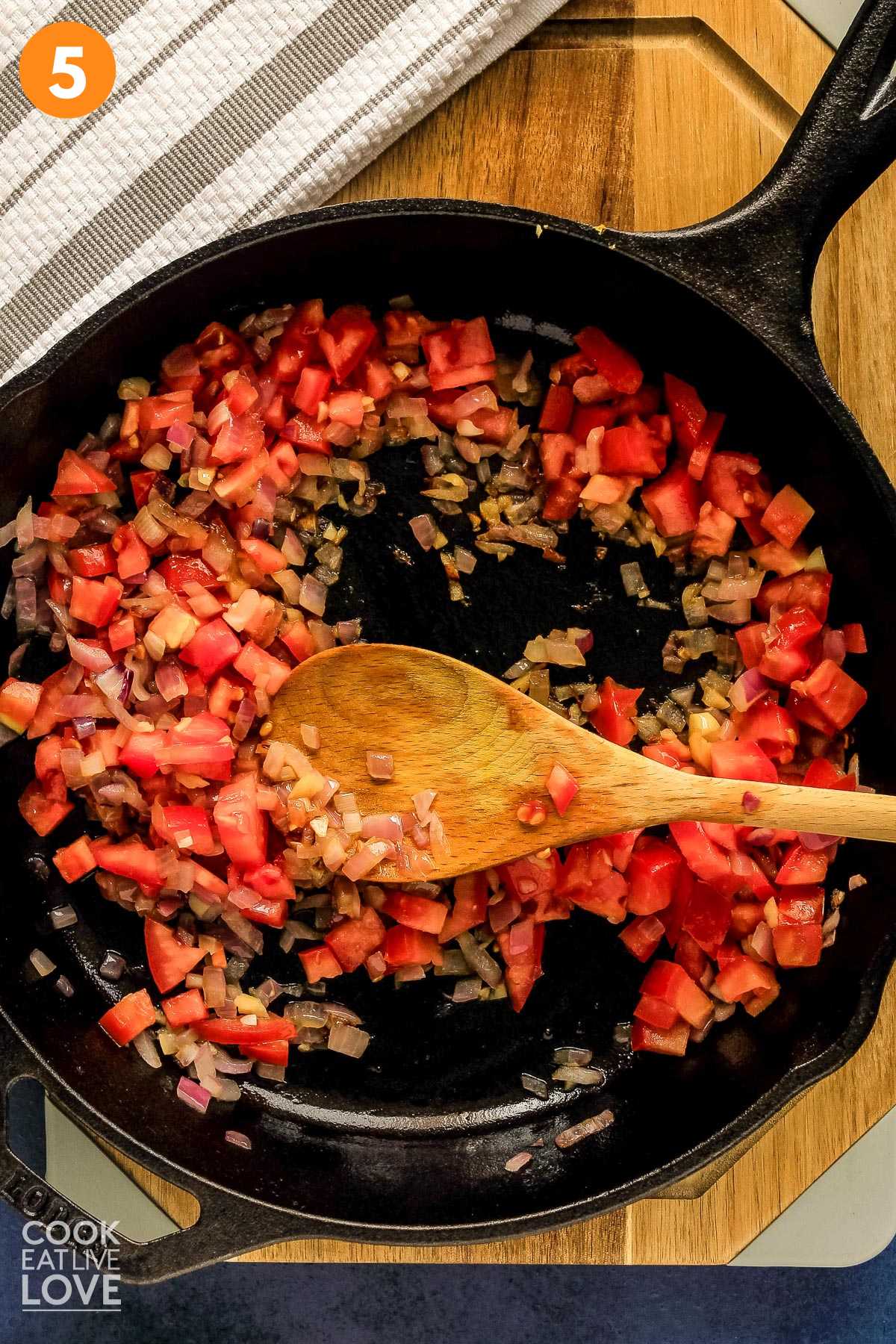 Vegetables in cast iron skillet cooking.