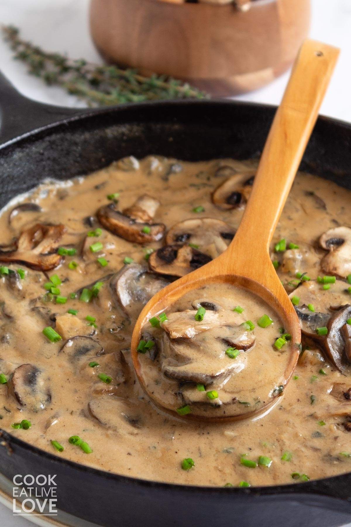 A skillet of mushroom sauce without cream with a spoon in it.