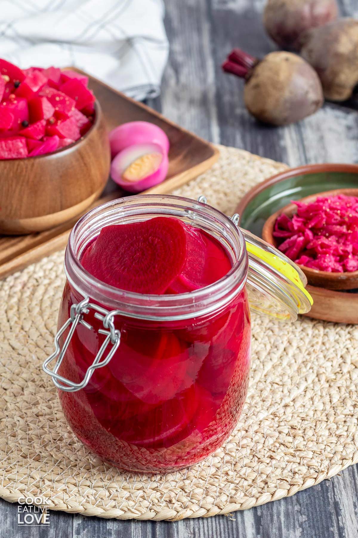 A jar of quick pickled beets without sugar on the table with the hinge lid open and sliced beets in the jar.