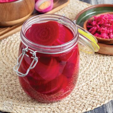 A jar of pickled beets no sugar on the table with the lid back to show the slices inside.