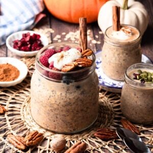 Glass jar of overnight oats with pumpkin seeds and cranberries