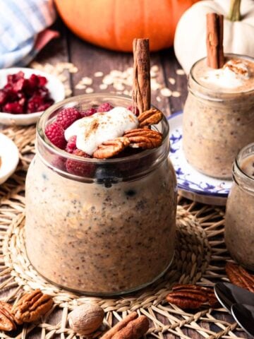 Glass jar of overnight oats with pumpkin seeds and cranberries