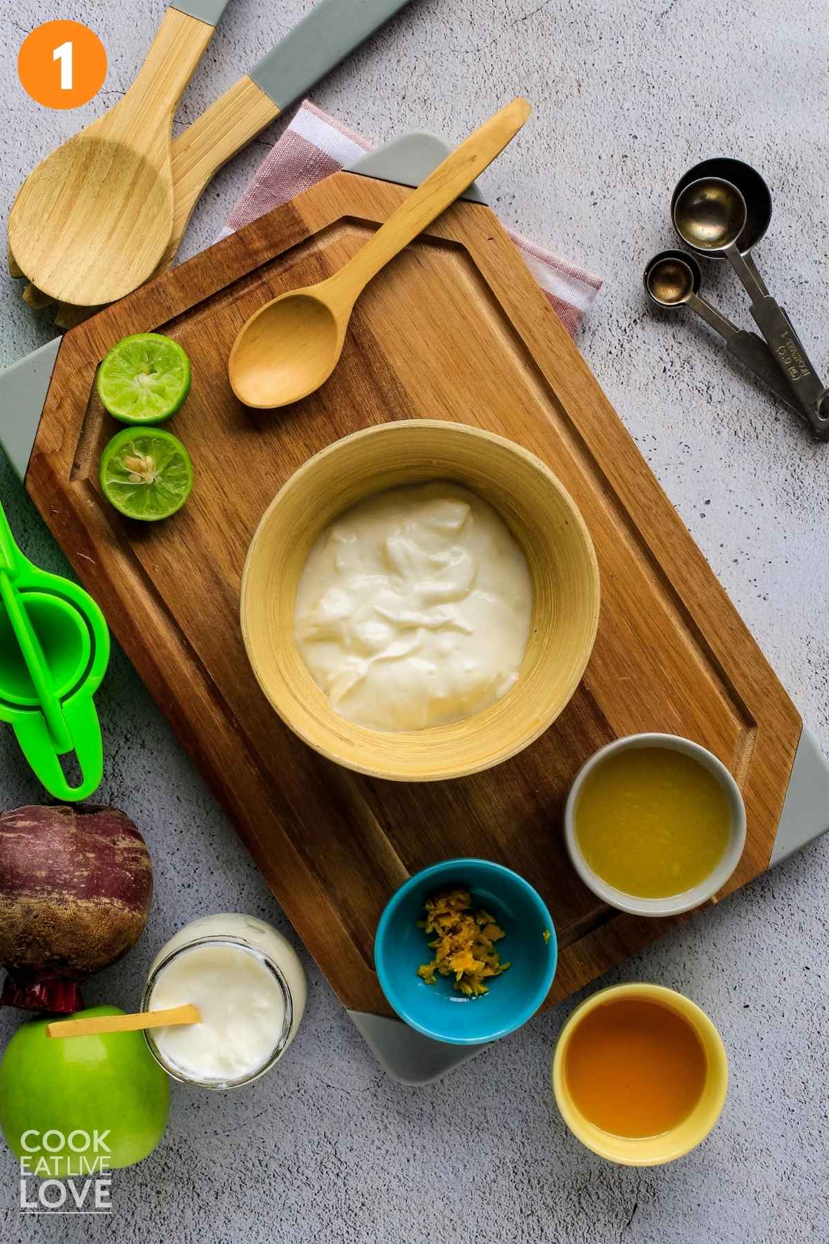 The ingredients to make the yogurt dressing in a bowl on a cutting board.