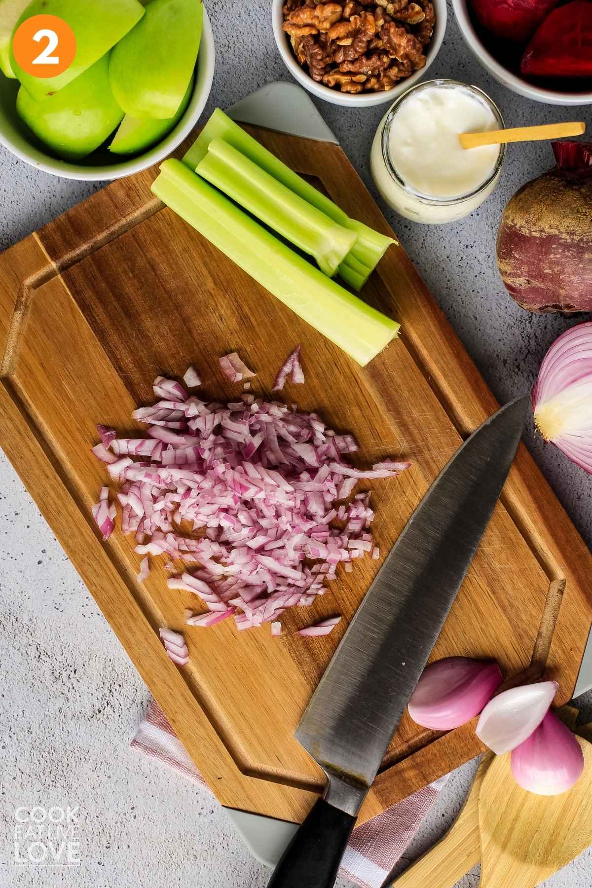 Diced onions on a cutting board with a knife to the side.