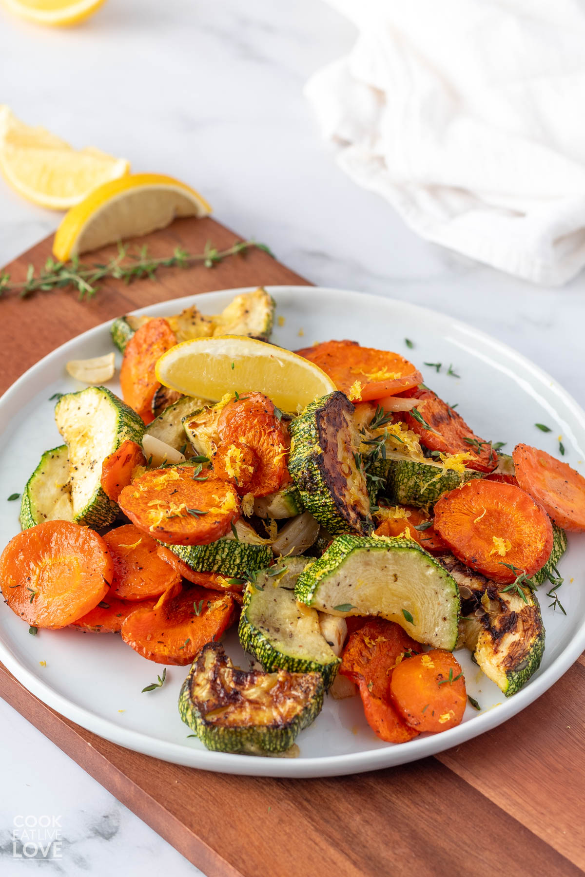 A plate of roasted carrots and zucchini on a white plate.