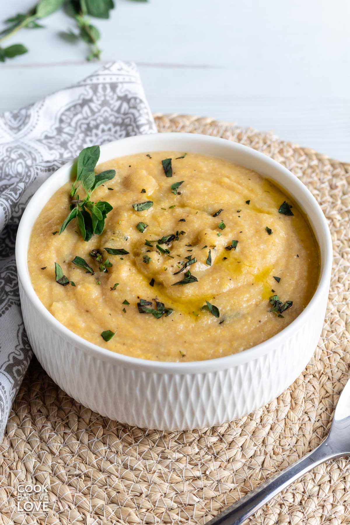 A bowl of creamy polenta cooked in the slow cooker served up in a bowl.