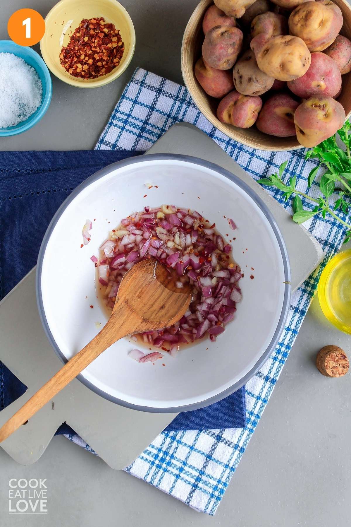 Onions and garlic in a bowl with the red wine vinegar.